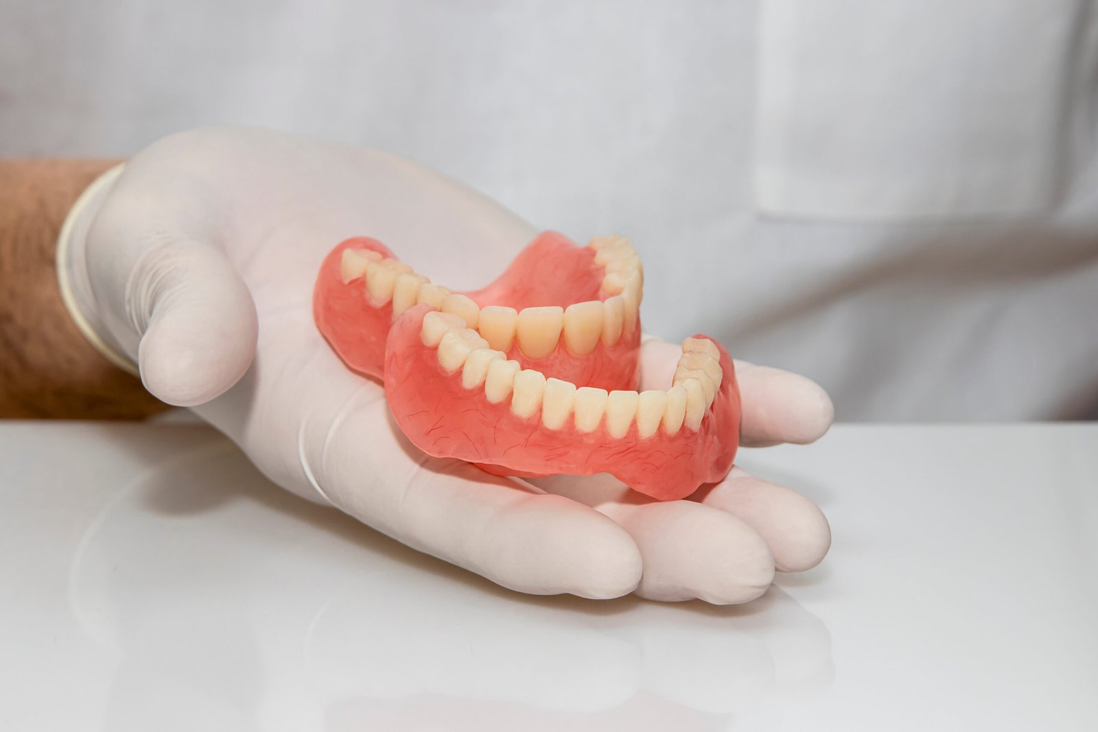 Denturist holding Dentures