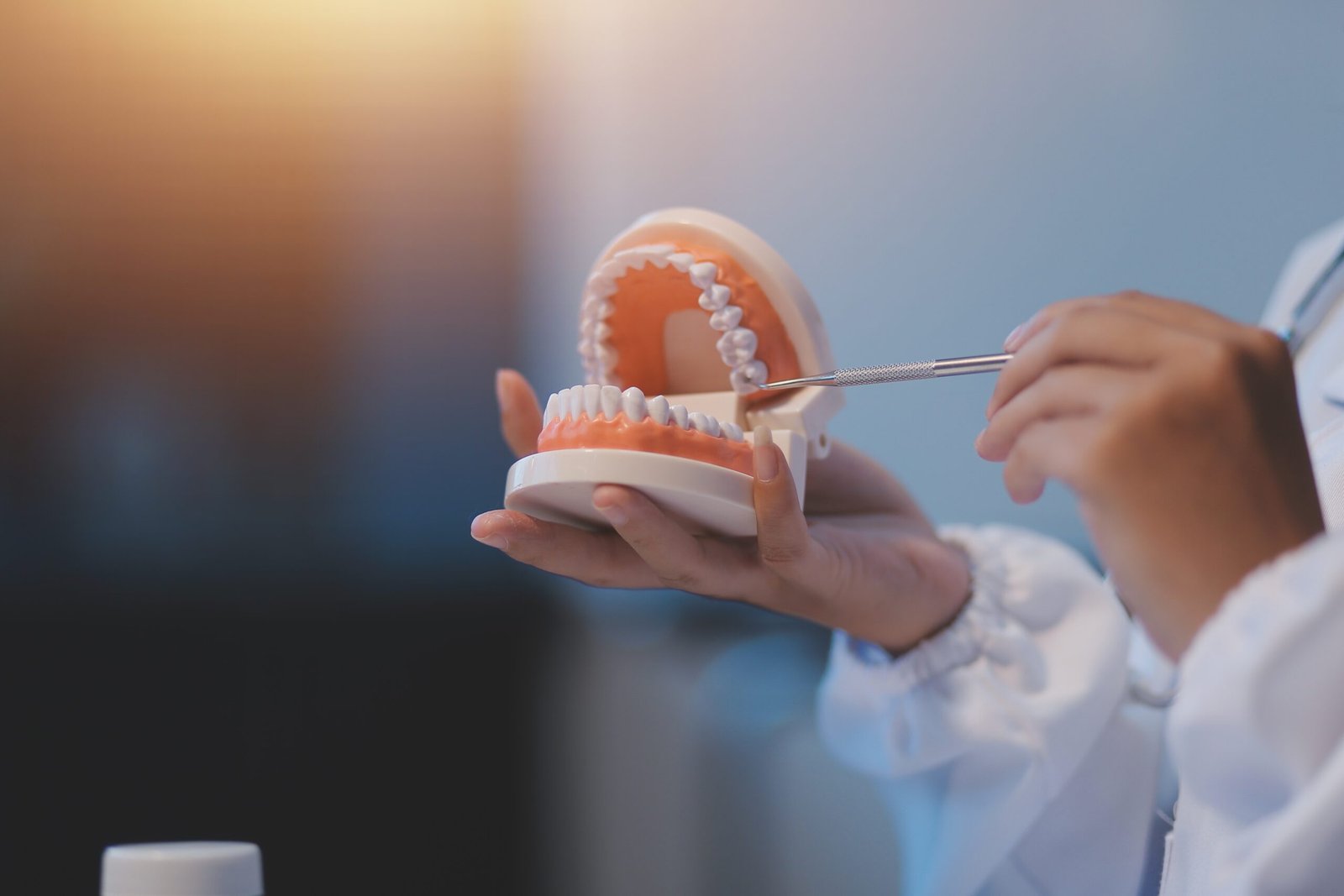 Dentist Holding and Pointing at Dentures